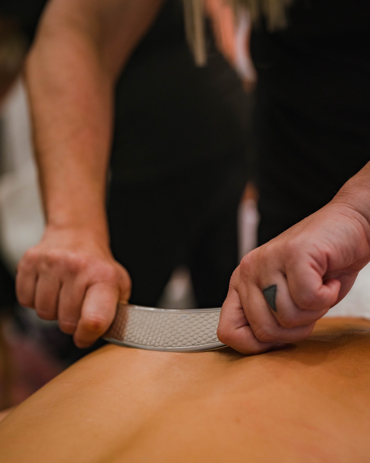 Scraping therapy on a client's back at Flex Fitness